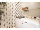 Laundry room with patterned wallpaper, wire rack shelving, front load washer and dryer at 1603 E Market St, Indianapolis, IN 46201