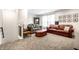 Carpeted living room features a brown leather couch, a gray fabric couch, an ottoman and bookcase at 1603 E Market St, Indianapolis, IN 46201