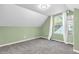 Charming bedroom featuring a slanted ceiling, large window, and cozy carpet at 1621 E 44Th St, Indianapolis, IN 46205