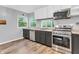 Bright kitchen with stainless steel appliances, wood floors and gray cabinets at 1621 E 44Th St, Indianapolis, IN 46205