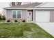 Charming home with a white door, an attached garage, and well-maintained landscaping at 1631 W Paula Dr, Columbus, IN 47201