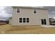 Beige two-story home featuring a sliding glass door leading to a concrete patio and a spacious backyard area at 17026 Cowbell Dr, Noblesville, IN 46060