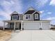 New two-story home showcasing a two-car garage, neutral siding, and a charming front porch at 17026 Cowbell Dr, Noblesville, IN 46060