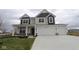 Two-story home featuring a two-car garage, covered porch, and neutral color palette at 17026 Cowbell Dr, Noblesville, IN 46060