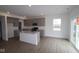 Bright kitchen featuring an island, stainless appliances, light gray cabinets, and hardwood floors at 17026 Cowbell Dr, Noblesville, IN 46060