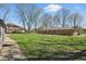 Large backyard with mature trees, grass and patio area perfect for outdoor activities at 1750 W Stop 11 Rd, Indianapolis, IN 46217