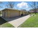 Back exterior view of the home showing the garage, long driveway, and manicured lawn at 1750 W Stop 11 Rd, Indianapolis, IN 46217