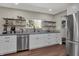 Updated kitchen with stainless steel appliances, gray countertops, white cabinets and floating shelves at 1750 W Stop 11 Rd, Indianapolis, IN 46217