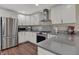 This bright kitchen features stainless appliances, white cabinets, gray countertops and a modern range hood at 1750 W Stop 11 Rd, Indianapolis, IN 46217