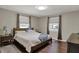 Cozy main bedroom featuring a wood bed frame, two side tables, and large windows at 1750 W Stop 11 Rd, Indianapolis, IN 46217
