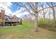 Spacious backyard featuring a deck with outdoor seating, mature trees, and serene wooded backdrop at 206 Somerville Rd, Anderson, IN 46011