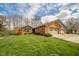 Charming brick home featuring an attached three car garage, well-manicured lawn, and mature trees at 206 Somerville Rd, Anderson, IN 46011