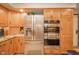 Stainless steel refrigerator and double ovens are surrounded by custom wood cabinetry at 206 Somerville Rd, Anderson, IN 46011