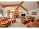 Comfortable living area with vaulted ceiling, beams, fireplace, and plush leather seating at 206 Somerville Rd, Anderson, IN 46011