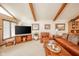 Bright living space with vaulted ceiling, wooden beams, and comfortable leather furnishings at 206 Somerville Rd, Anderson, IN 46011
