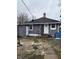 Single-story home with gray siding, a dark roof, and an aged concrete path leading to the front door at 2124 W 64Th St, Indianapolis, IN 46260