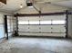 Spacious garage featuring a concrete floor, an automatic door opener, and built-in shelving at 2260 N Graham Ave, Indianapolis, IN 46218