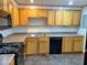 Functional kitchen features light wood cabinets, a black dishwasher, and black electric stove at 2260 N Graham Ave, Indianapolis, IN 46218