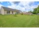 Well-maintained backyard with green grass, a tan home, and a wooden fence at 2390 Lakecrest Dr, Columbus, IN 47201