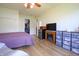 Spacious bedroom featuring hardwood floors, a ceiling fan, a closet, a large window, and mini fridge at 2390 Lakecrest Dr, Columbus, IN 47201