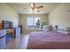 Cozy bedroom featuring hardwood floors, a ceiling fan, a large window, and built in fireplace at 2390 Lakecrest Dr, Columbus, IN 47201
