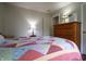 Bedroom with a colorful patchwork quilt, soft lighting, and wood dresser at 2390 Lakecrest Dr, Columbus, IN 47201