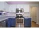 Kitchen with two-tone cabinets, stainless steel appliances, under cabinet lighting, and wood-look vinyl flooring at 2390 Lakecrest Dr, Columbus, IN 47201
