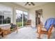 Bright sun room with carpeted floors, fan, three large windows, white trim, and a sliding glass door to the back yard at 2390 Lakecrest Dr, Columbus, IN 47201