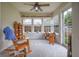 Bright sun room with carpeted floors, fan, three large windows, white trim, and a sliding glass door to the back yard at 2390 Lakecrest Dr, Columbus, IN 47201