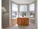 Bright seating area with natural light from a large bay window and a wooden cabinet at 2390 Lakecrest Dr, Columbus, IN 47201