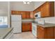 Functional kitchen features wood cabinets, white appliances, tile floor, and plenty of counter space at 2755 Rylee Ct, Greenwood, IN 46143