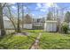 Large backyard with green grass, a fire pit, a shed, and a fence separating the property from neighbors at 282 N Vine St, Plainfield, IN 46168