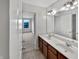 Bathroom features double sink vanity with wood cabinets, tile floor, and a view to the bedroom at 2859 Dursillas Dr, Plainfield, IN 46168