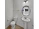 Half bathroom with pedestal sink, round mirror and tile flooring at 2859 Dursillas Dr, Plainfield, IN 46168
