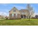 Beautiful two-story home with a manicured lawn, stone accents, and charming architectural details at 2859 Dursillas Dr, Plainfield, IN 46168