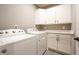 Well-lit laundry room featuring white cabinets, counter space, and modern washer and dryer at 2932 Camden Ct, Greenwood, IN 46143