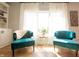 Bright living room featuring two teal chairs, hardwood floors, and a sun-filled window at 2932 Camden Ct, Greenwood, IN 46143