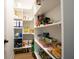 Organized walk-in pantry with shelving stocked with food items and household supplies at 2932 Camden Ct, Greenwood, IN 46143