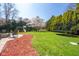 Well-manicured backyard with mature trees, a playground, and a trampoline, perfect for outdoor activities at 3165 Hazel Foster W Ct, Carmel, IN 46033