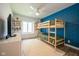 Bright bedroom with a bunk bed, blue accent wall, shelves, and window at 3165 Hazel Foster W Ct, Carmel, IN 46033