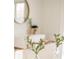The dining room table has flowers with a round mirror and modern white cabinet in the background at 3165 Hazel Foster W Ct, Carmel, IN 46033