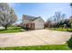 View of the driveway leading to a two-story home with a well-maintained lawn, basketball court, and a two-car garage at 3165 Hazel Foster W Ct, Carmel, IN 46033