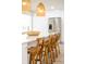 The kitchen island features bar stool seating, white quartz countertop, modern pendant lighting, and stainless steel appliances at 3165 Hazel Foster W Ct, Carmel, IN 46033