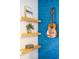 Close-up of stylish floating shelves with decorative guitar and art at 3165 Hazel Foster W Ct, Carmel, IN 46033