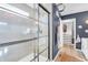 Contemporary bathroom featuring a glass-enclosed shower, wood floors, and a dark blue accent wall with an ornate clock at 4285 Nottinghill Dr, Avon, IN 46123