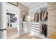 Walk-in closet with wood accent wall with mirror and custom shelving and drawers for storage at 4285 Nottinghill Dr, Avon, IN 46123