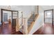Hallway with modern staircase and cable railing and open doorway to the foyer at 4285 Nottinghill Dr, Avon, IN 46123