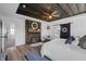 Primary bedroom with fireplace, barn door, wood plank ceiling and plank accent wall at 4285 Nottinghill Dr, Avon, IN 46123