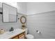 Charming powder room with wood-look plank walls, modern vanity, and decorative mirror at 4285 Nottinghill Dr, Avon, IN 46123