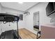 Well-equipped workout room with treadmill, mirror, and wall-mounted equipment, ideal for staying active at home at 4285 Nottinghill Dr, Avon, IN 46123